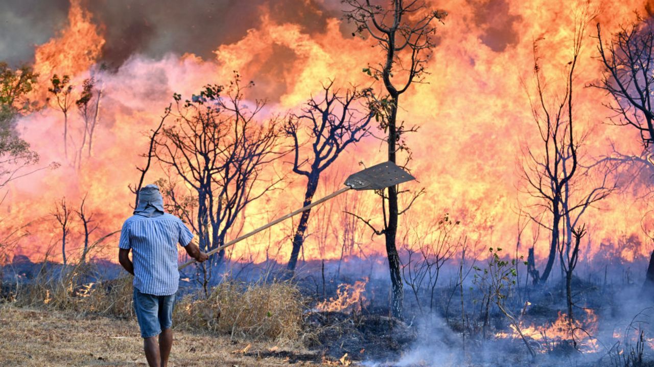 A resident near Brasilia National Park tries to contain the forest fire that is raging in the park so that it doesn't reach their homes in Brasilia, Brazil, on September 15, 2024. In the midst of the worst drought since records have been kept, Brazil continues to battle thousands of fires on September 13, with smoke affecting some of its major cities, such as Sao Paulo and Rio de Janeiro, and neighboring countries. (Photo by EVARISTO SA / AFP) (Photo by EVARISTO SA/AFP via Getty Images)