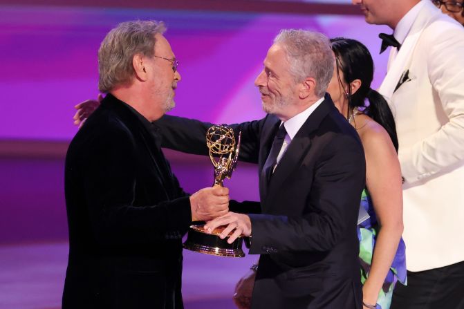 Billy Crystal, left, hands the Emmy to Jon Stewart after "The Daily Show" won outstanding talk series.