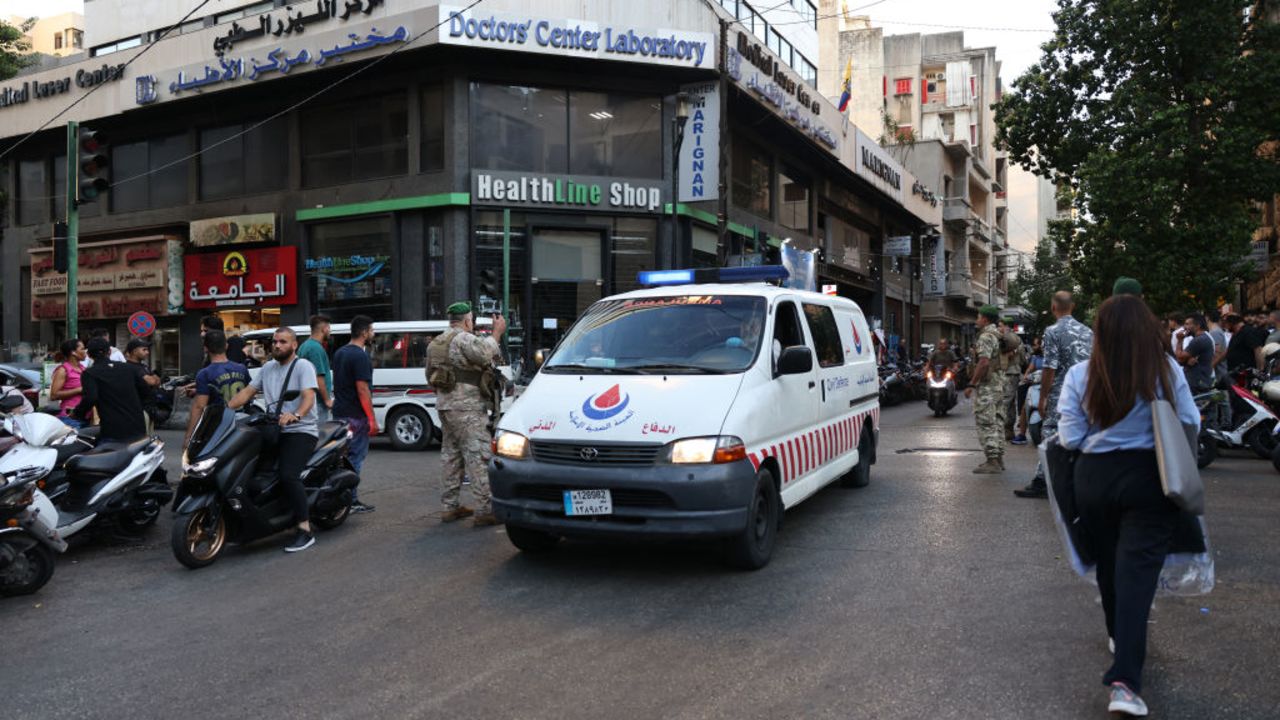 Lebanese army soldiers stand guard as an ambulance rushes wounded people to a hospital in Beirut on September 17, 2024, after explosions hit locations in several Hezbollah strongholds around Lebanon amid ongoing cross-border tensions between Israel and Hezbollah fighters. Hundreds of people were wounded when Hezbollah members' paging devices exploded simultaneously across Lebanon on September 17, in what a source close to the militant movement said was an "Israeli breach" of its communications. (Photo by ANWAR AMRO / AFP) (Photo by ANWAR AMRO/AFP via Getty Images)