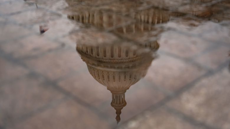 The dome of the US Capitol reflected in a puddle in Washington, DC, on September 18, 2024.