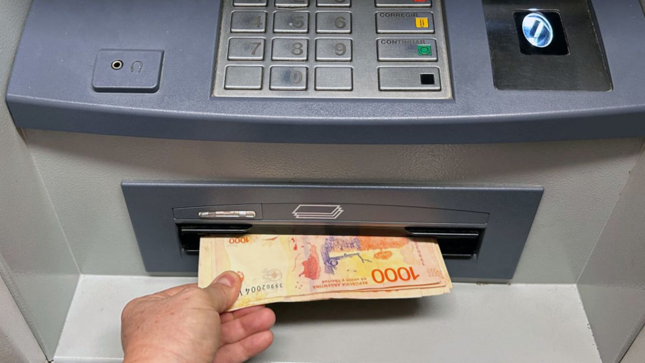 A woman withdraws Argentine pesos from an ATM machine at a bank in Buenos Aires on September 19, 2024. (Photo by STRINGER / AFP) (Photo by STRINGER/AFP via Getty Images)