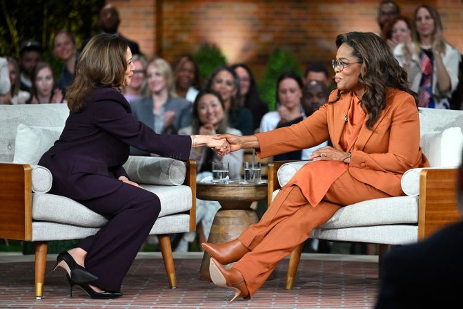 Harris shakes hands with media mogul Oprah Winfrey at a rally in Farmington Hills, Michigan, on September 19.