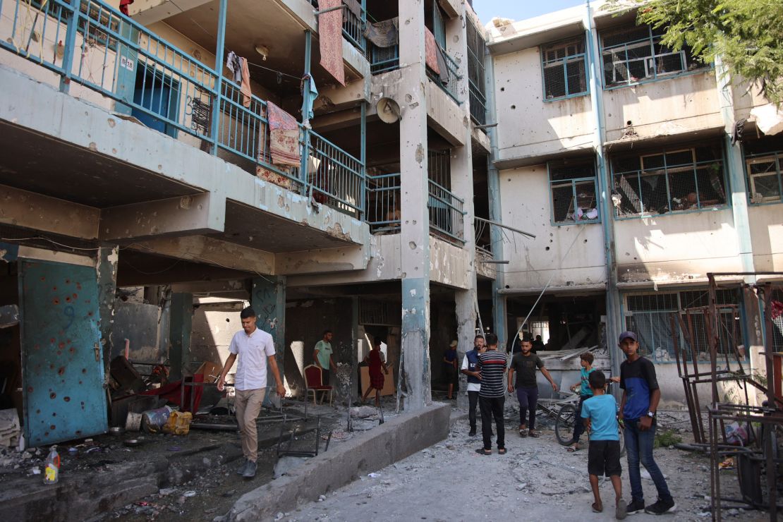 Palestinians inspect the damage at the site of the Israeli strike.