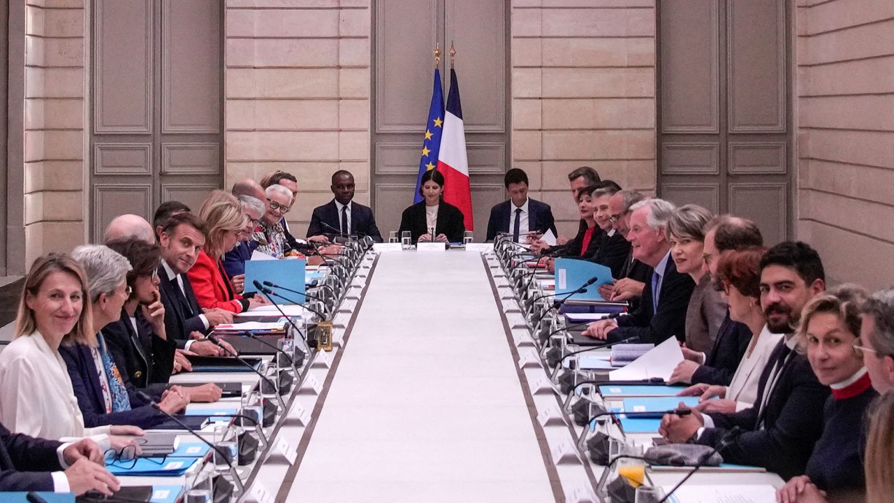 TOPSHOT - French President Emmanuel Macron (L) and French Prime Minister Michel Barnier (R) meet with members of the new government during the weekly cabinet meeting at the Elysee Palace, in Paris, on September 23, 2024. (Photo by Christophe Ena / POOL / AFP) (Photo by CHRISTOPHE ENA/POOL/AFP via Getty Images)