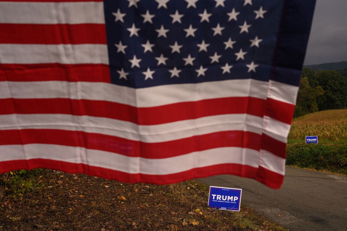 Campaign signs for President Donald Trump and an American flag are seen at a farm in Smithton, Pennsylvania, in September 2024. Compared to 1995, today's Republicans are much more reliant on working-class voters.