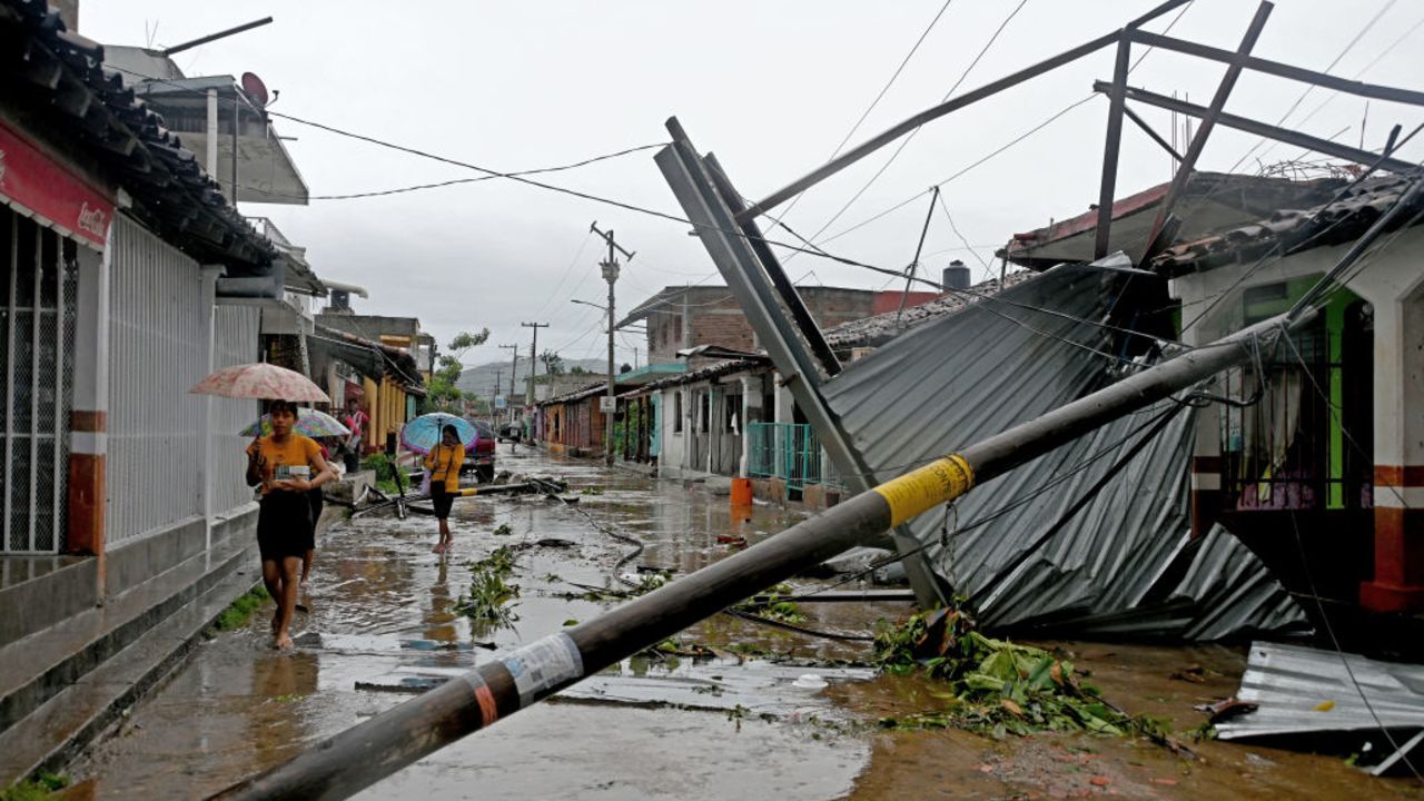 TOPSHOT - A group of women walk past to damages on a street as a result of Hurricane John in San Marcos, Guerrero State, Mexico, on September 24, 2024. Two people died in Mexico as a result of John, which made landfall in the Pacific as a category 3 hurricane on September 23 at night but dispersed on Tuesday, while the Mexican Caribbean was declared on alert for storm Helene. (Photo by Francisco Robles / AFP) (Photo by FRANCISCO ROBLES/AFP via Getty Images)