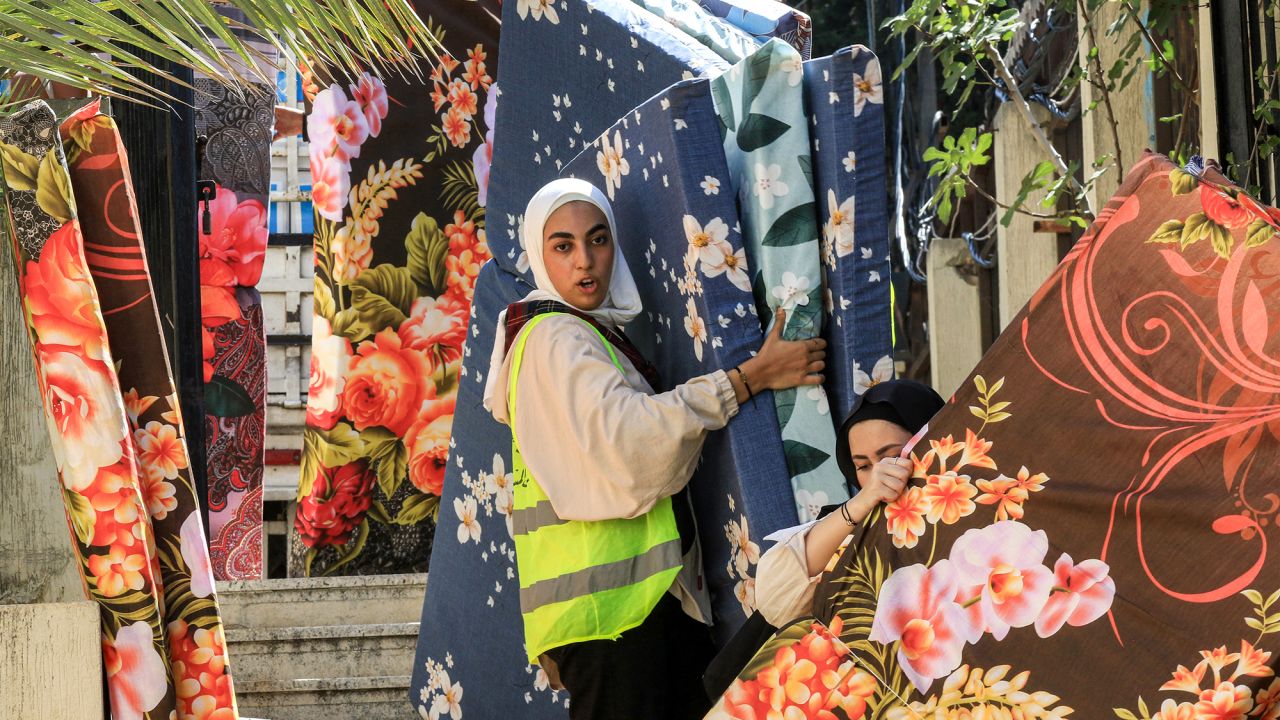 Volunteers transport mattresses for people displaced by conflict from southern Lebanon at a temporary reception center in the southern city of Sidon on September 25.