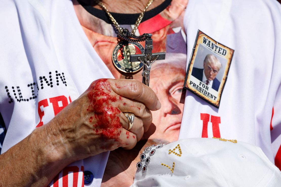 A woman holds a crucifix during a prayer at a campaign rally for former President Donald Trump on September 21, 2024, in Wilmington, North Carolina.