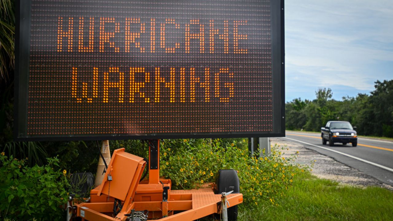 A sign displays a hurricane warning along a roadside as preparations are made for the arrival of Hurricane Helene, in Cedar Key, Florida on September 25, 2024. Thousands of residents on Wednesday began evacuating parts of coastal Florida as the US state braces for Hurricane Helene, forecast to barrel ashore as a powerful, potentially deadly storm. Helene strengthened into a hurricane mid-morning in the Gulf of Mexico and is "expected to bring life-threatening storm surge, damaging winds, and flooding rains to a large portion of Florida and the Southeastern United States," the National Hurricane Center in Miami said in its latest bulletin. (Photo by Miguel J. Rodriguez Carrillo / AFP) (Photo by MIGUEL J. RODRIGUEZ CARRILLO/AFP via Getty Images)