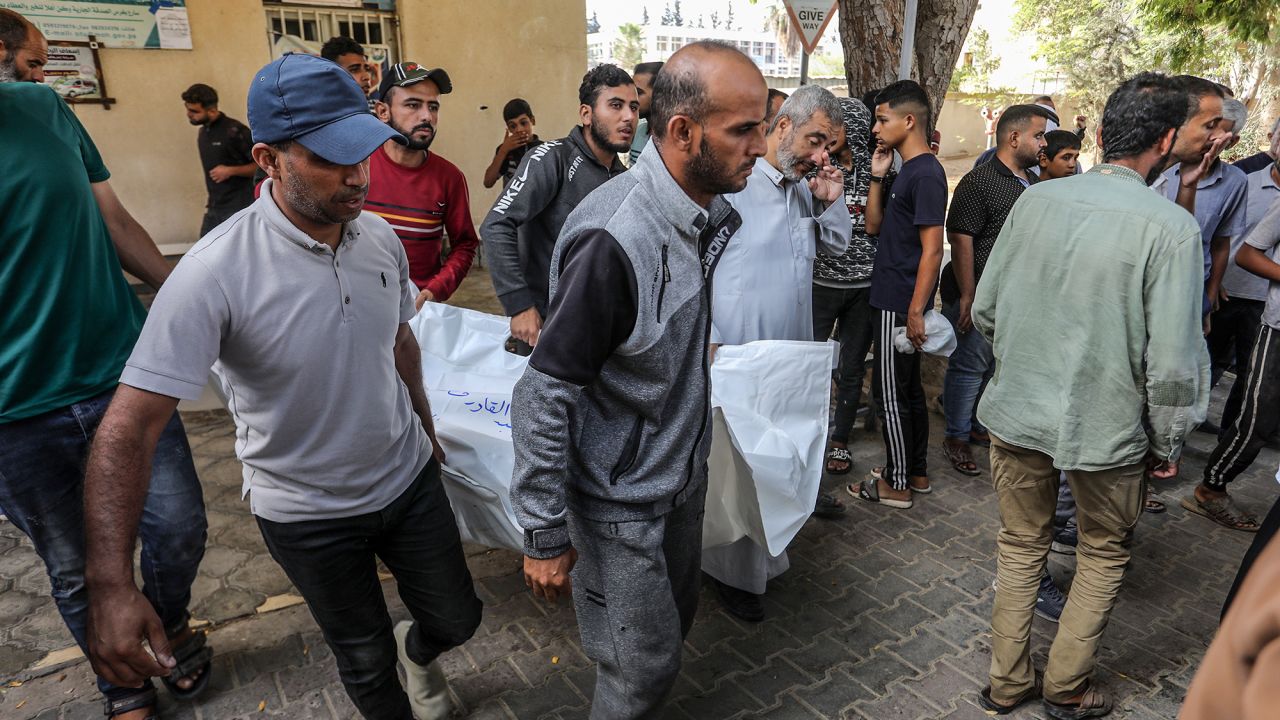 Palestinians carry a shrouded body as the bodies of those who lost their lives in Israeli attack on Rafah are brought to the European Hospital in Khan Younis, Gaza, on September 26.