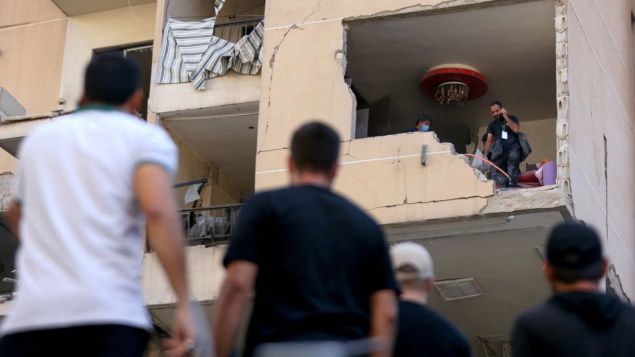 People inspect the damage in a building targeted by an Israeli air strike in Beirut's southern suburbs on September 26.