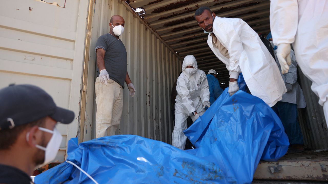 People unload a truck carrying 88 bodies, which according to the Palestinian health ministry entered Gaza from Israel the day before, to be buried in a mass grave in Khan Younis, on September 26.