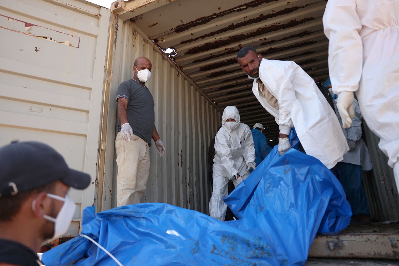 People unload a truck carrying 88 bodies, which according to the Palestinian health ministry entered Gaza from Israel the day before, to be buried in a mass grave in Khan Younis, on September 26.