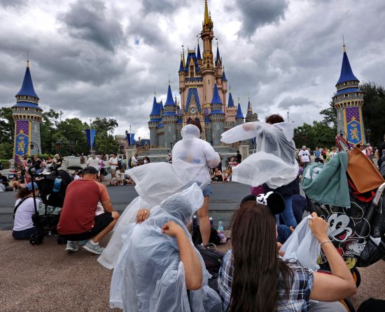 Khách tham quan mặc áo choàng tại Walt Disney World ở Bay Lake, Florida, vào thứ năm khi cơn bão Helene bắt đầu đổ bộ.