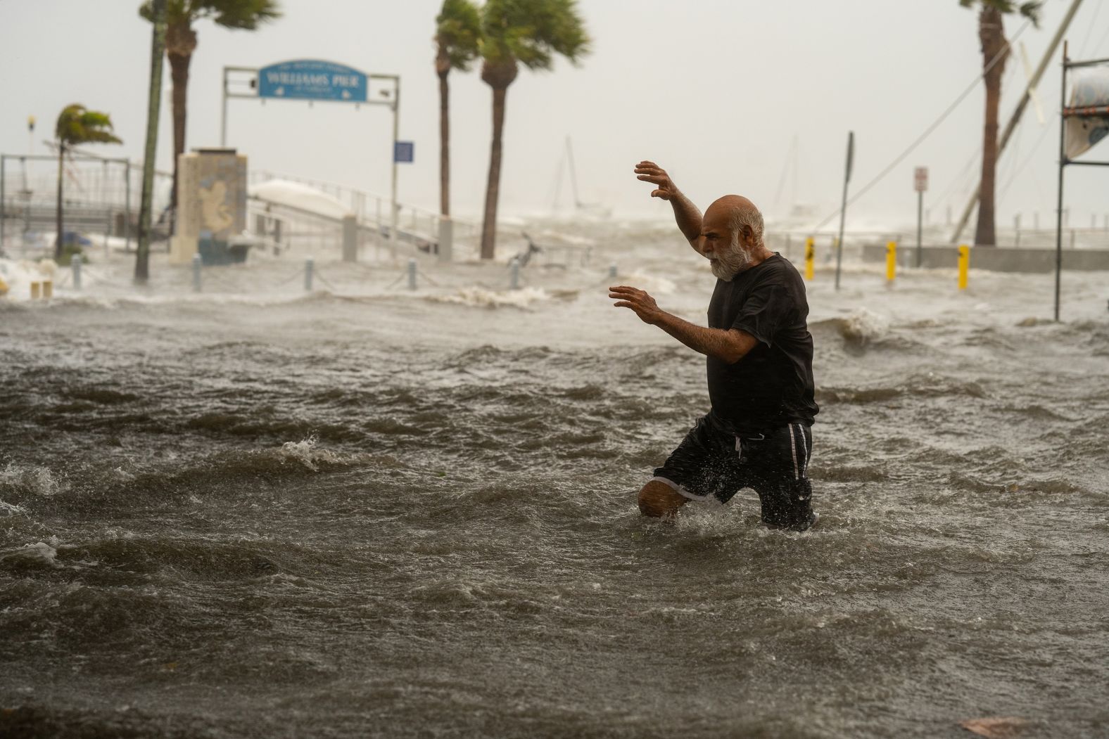 A man crosses a flooded area on the coast of Gulfport, Florida, on September 26.