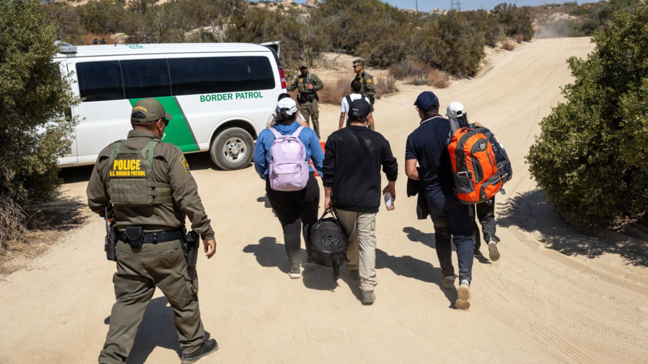 JACUMBA HOT SPRINGS, CALIFORNIA - SEPTEMBER 19: U.S. Border Patrol agents take asylum seekers into custody after they crossed a remote area of the U.S.-Mexico border on September 19, 2024 near Jacumba Hot Springs, California. Immigrant border crossings remain low months after the Biden Administration's executive order banning most asylum claims at the southern border. The issues of asylum and illegal immigration remain motivating topics for voters ahead of the upcoming U.S. election. (Photo by John Moore/Getty Images)