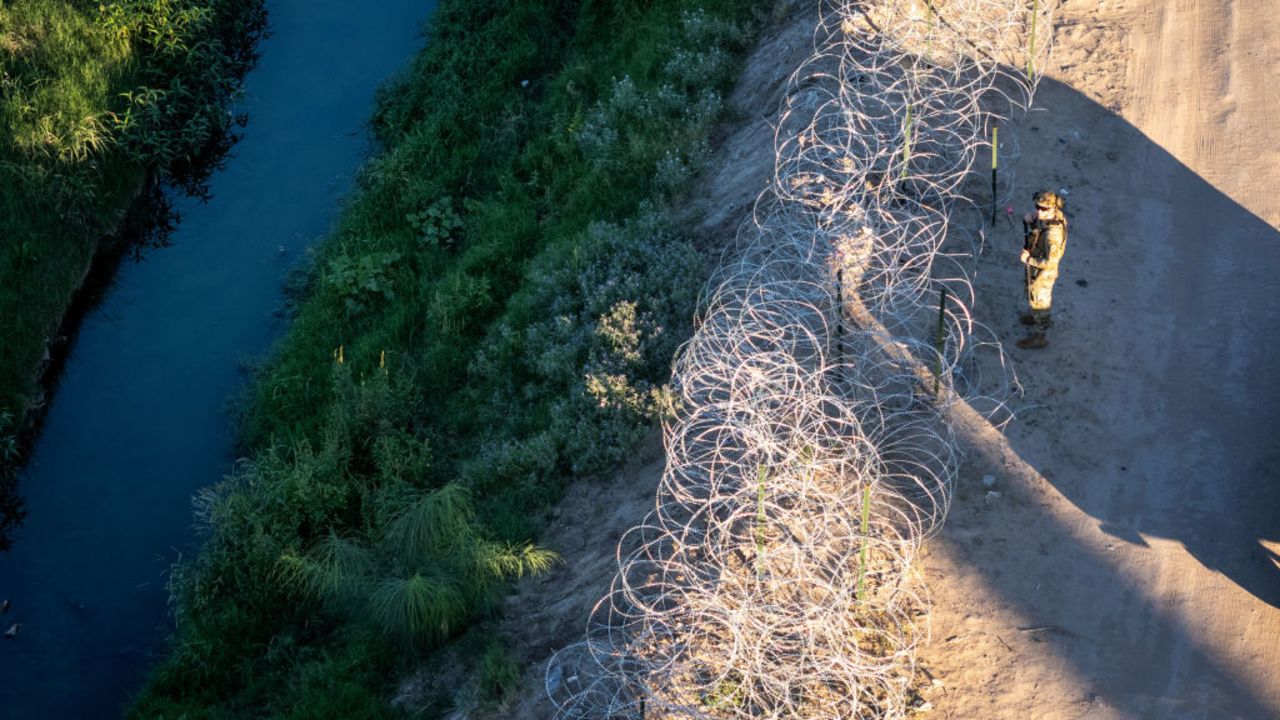 EL PASO, TEXAS - SEPTEMBER 18: From an aerial view a Texas National Guard soldier inspects razor wire along the bank of the Rio Grande at the U.S.-Mexico border on September 18, 2024 in El Paso, Texas. Immigrant border crossings remain low months after the Biden Administration's executive order banning most asylum claims at the southern border. The issues of asylum and illegal immigration remain motivating topics for voters ahead of the upcoming U.S. presidential election. (Photo by John Moore/Getty Images)