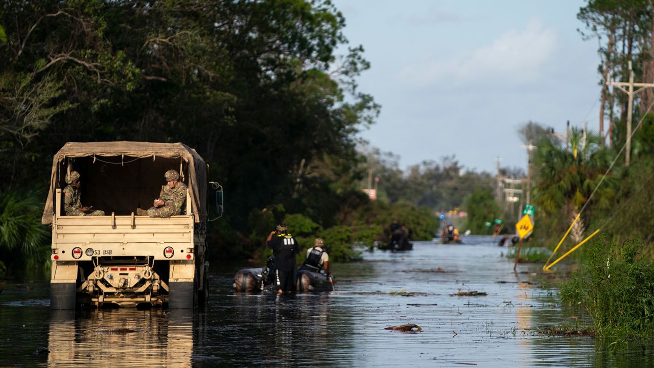 National guardsmen and others participate in missions to rescue people stranded in a flooded neighborhood in Steinhatchee, Florida, on Friday.