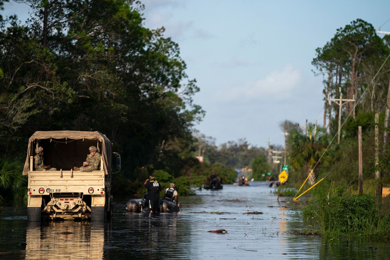 National guardsmen and others participate in missions to rescue people stranded in a flooded neighborhood in Steinhatchee, Florida, on Friday.