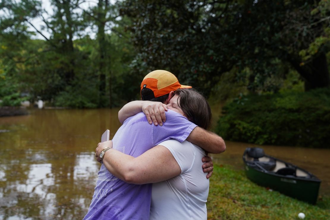 Dan Murphy hugs his coworker after taking his canoe to rescue them from their flooded home as streets flood near Peachtree Creek on September 27, 2024 in Atlanta, Georgia.