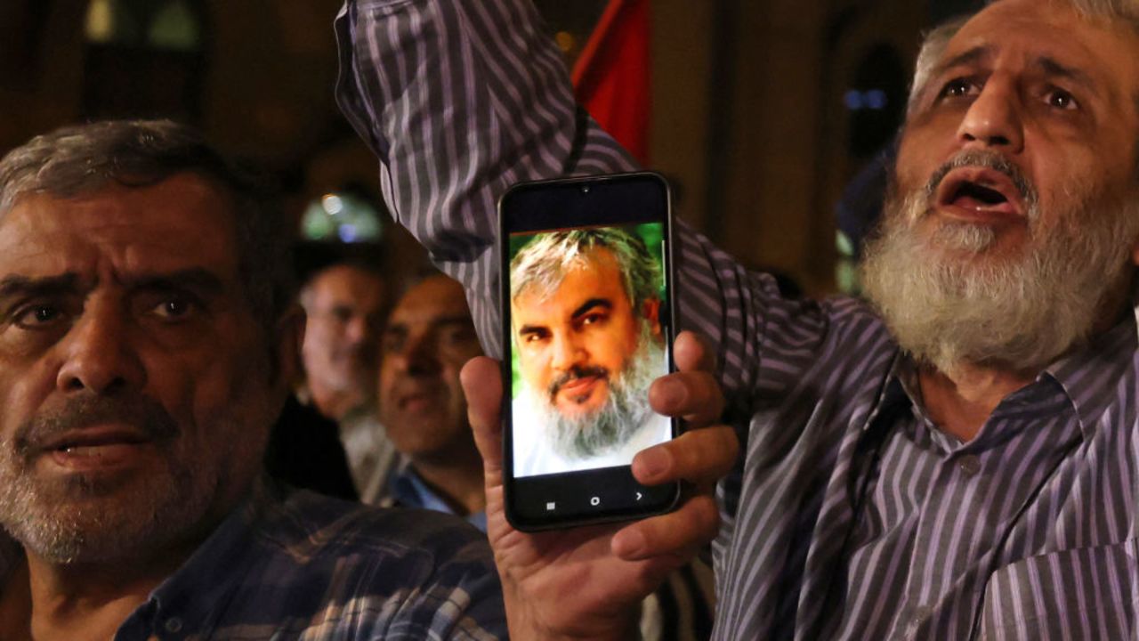 Men show photos of Hassan Nasrallah, Secretary-general of Hezbollah, as people demonstrate against Israel and the attack on Lebanon at Palestine square in Tehran on September 28, 2024. Israel conducted a wave of air strikes on the south of Lebanon's capital Beirut on September 27, 2024 that it said targeted Hezbollah's headquarters, warning of more to come as it told civilians to leave the densely populated neighbourhood. Israeli television networks reported that Hezbollah chief Hassan Nasrallah was the target of the strike, though a source close to the group said he was "fine". (Photo by ATTA KENARE / AFP) (Photo by ATTA KENARE/AFP via Getty Images)