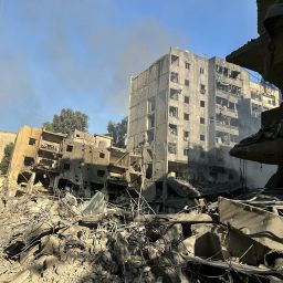 Smoke rises behind the devastation in the Haret Hreik neighbourhood of Beirut's southern suburbs, in the aftermath of the first wave of Israeli strikes on September 27, that levelled several buildings, on September 28, 2024. Israeli fighter jets bombarded the southern suburbs of Lebanon's capital overnight into September 28, sending panicked families fleeing massive strikes that were reportedly targeting Hezbollah chief Hassan Nasrallah.