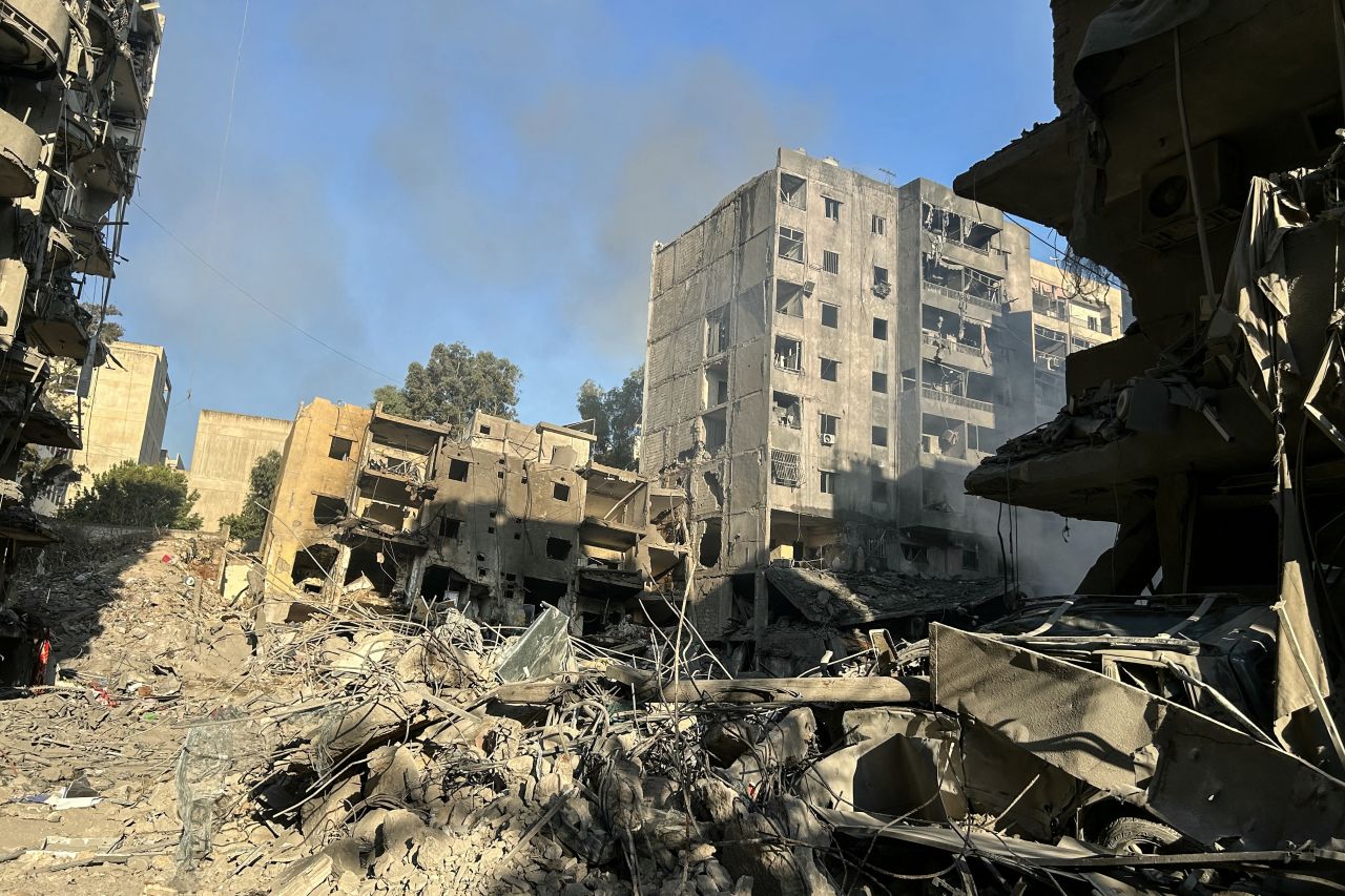 Smoke rises behind buildings destroyed by Israeli airstrikes in Beirut's southern suburbs on September 28.