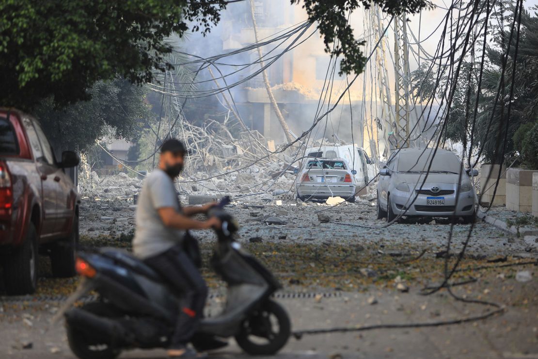 A man rides his motorbike through a neighborhood levelled by Israeli strikes, in the Hadath district, of Beirut's southern suburbs, on Saturday.