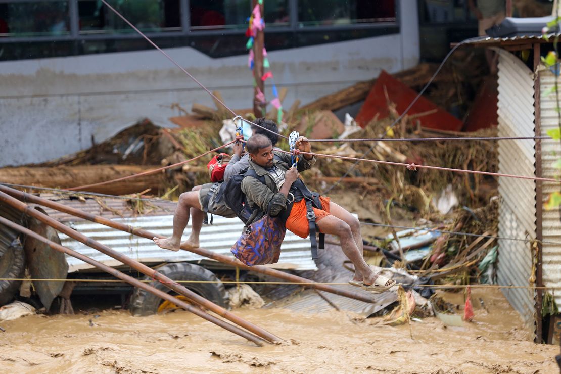 Nepal's Armed Police Force rescues stranded people using a zip line from a flooded river in Lalitpur, Nepal, on September 28, 2024.