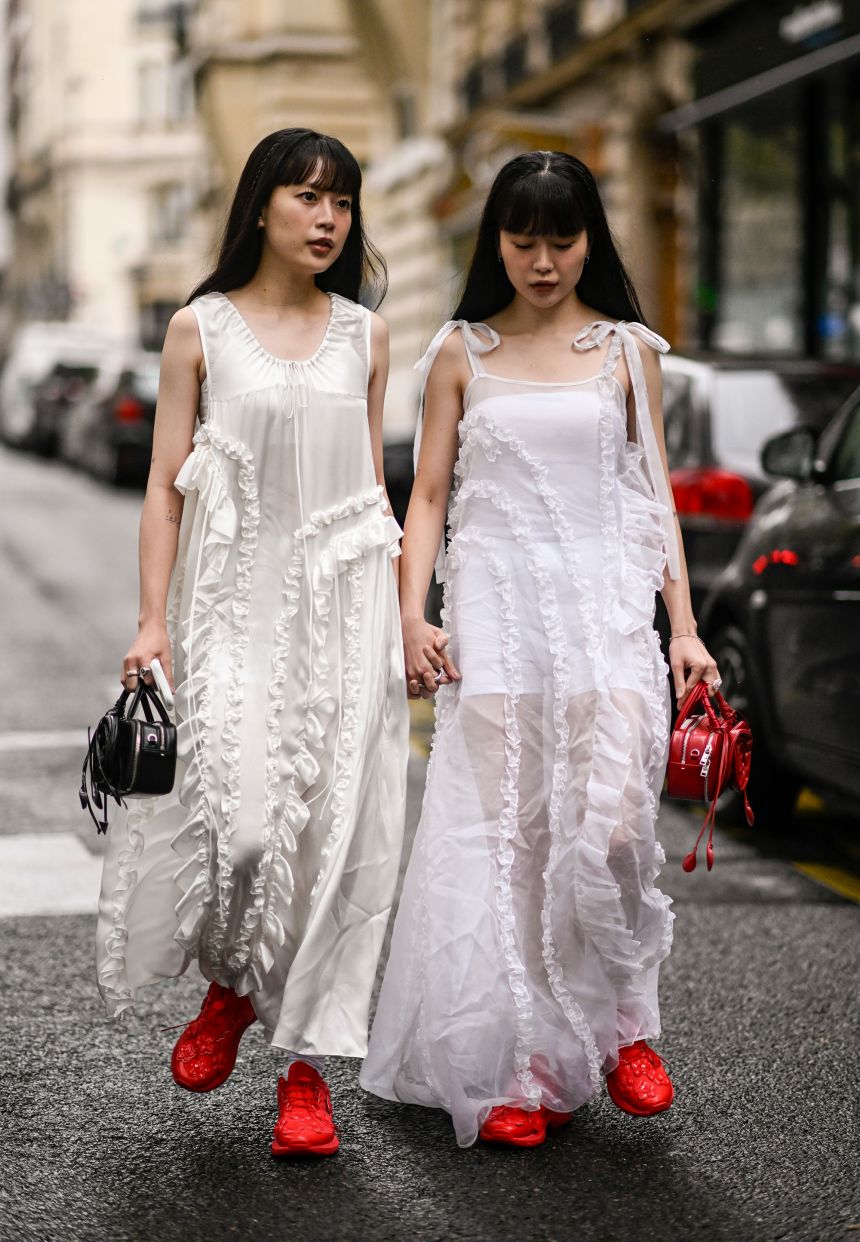 South Korean twin influencers Qjin and Qwon pair their Cecilie Bahnsen dresses with red shoes at Paris Fashion Week.