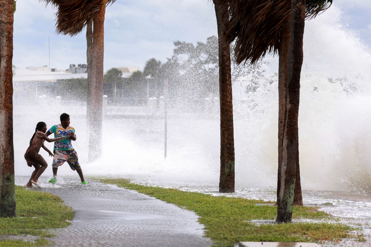 People are splashed by surf from Tampa Bay as Hurricane Helene passes offshore in St. Petersburg, Florida, on September 26.