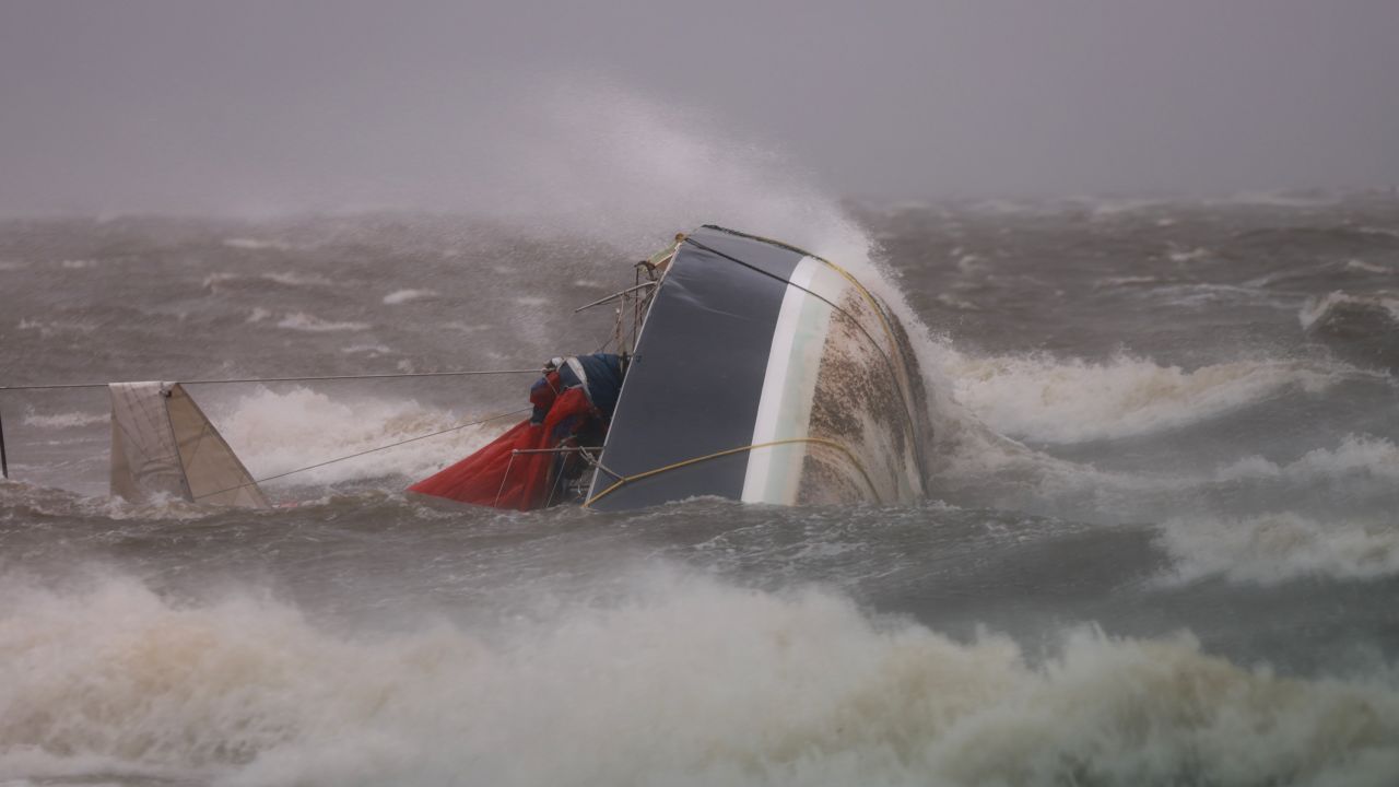 A capsized boat washes ashore as Hurricane Helene churns offshore in St. Petersburg, Florida, on September 26.