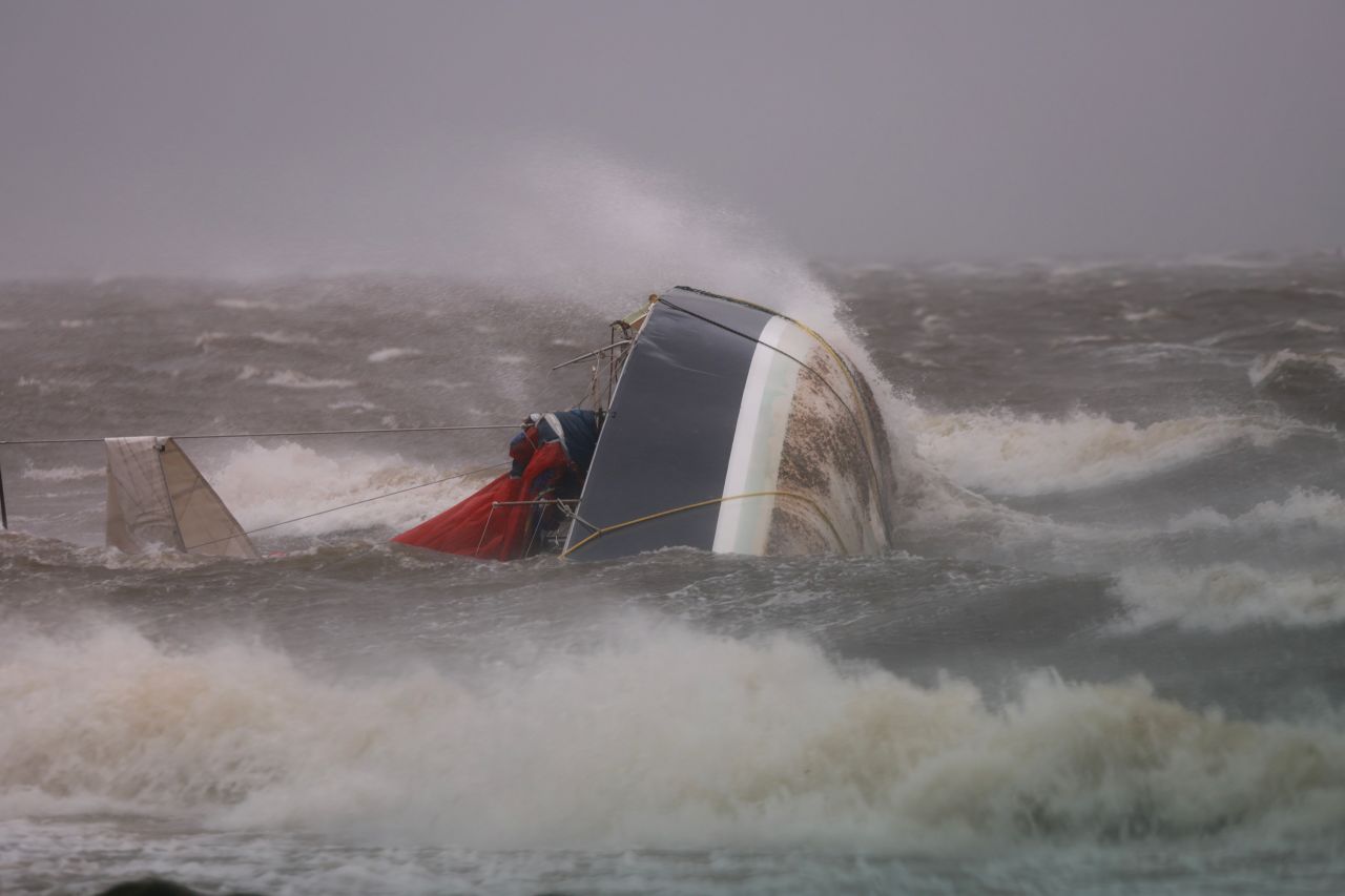 A capsized boat washes ashore as Hurricane Helene churns offshore in St. Petersburg, Florida, on September 26.