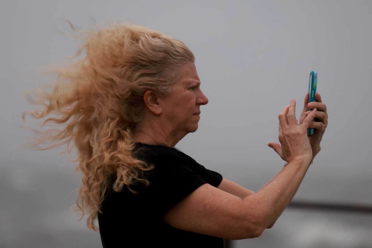 Carol Poulson uses her phone to document the impacts of Hurricane Helene as it builds offshore in St. Petersburg on September 26.