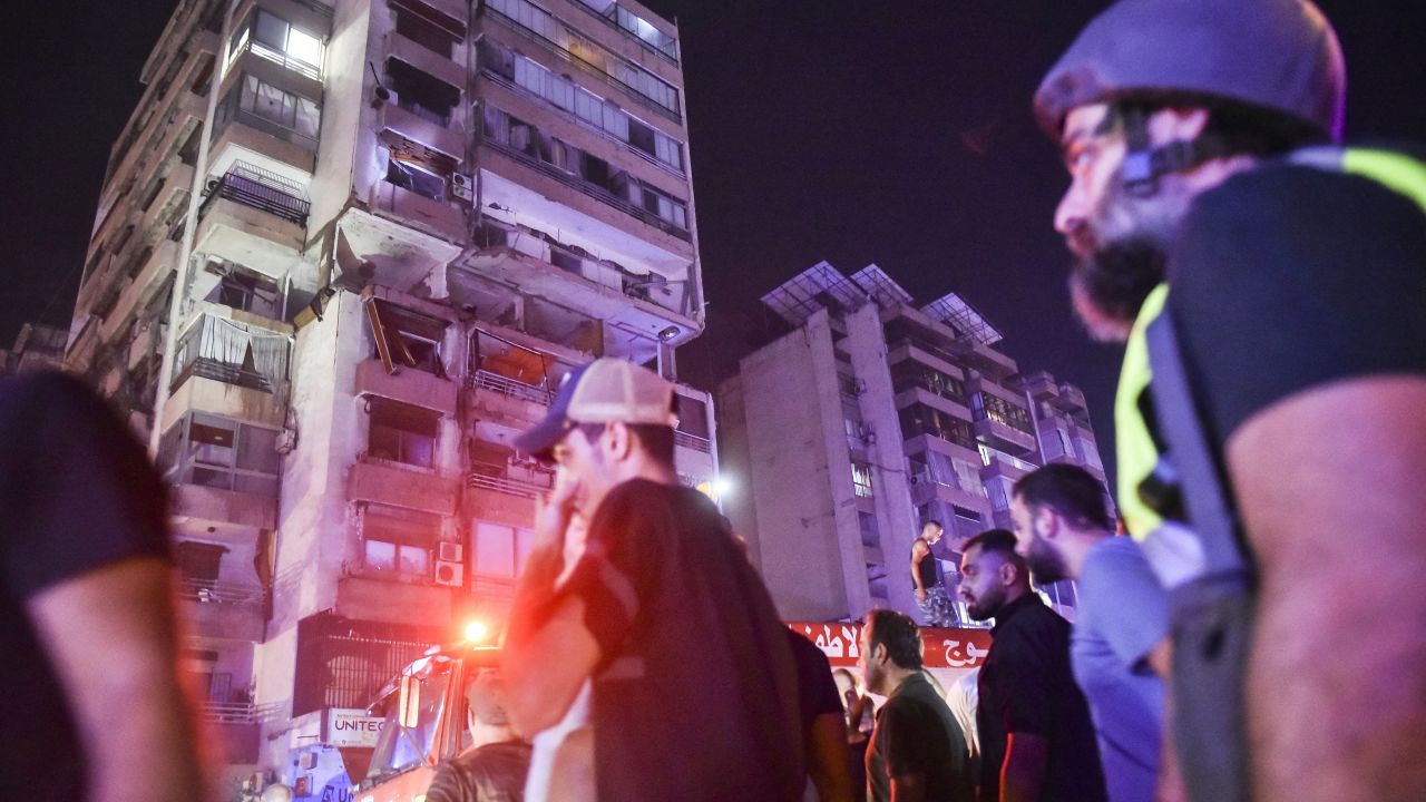 People gather outside an apartment building hit by an airstrike in Beirut on Monday.