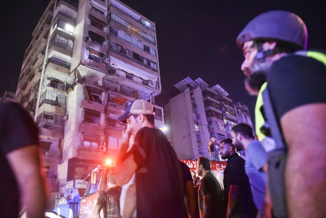 People gather outside an apartment building hit by an airstrike in Beirut on Monday.