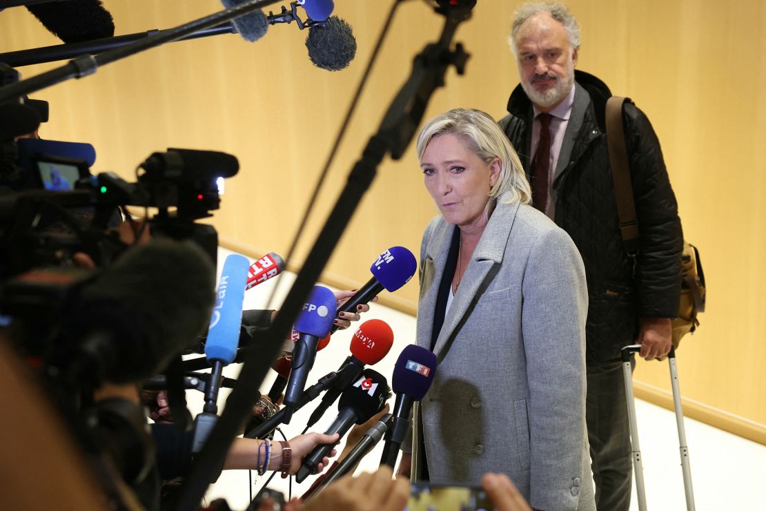 Marine Le Pen addresses the press as she arrives at a court house for a trial on suspicion of embezzlement of European public funds, in Paris on September 30, 2024.