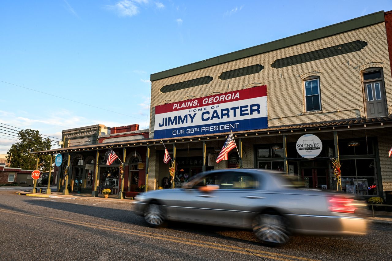 A car drives past a sign reading "Home of Jimmy Carter" in Plains, Georgia, on September 30.