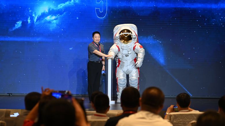 Yang Liwei, deputy chief designer of China's manned space program, stands beside China's moon-landing spacesuit during the opening ceremony of the 3rd Space Suit Technology Forum on September 28, 2024 in Chongqing, China.