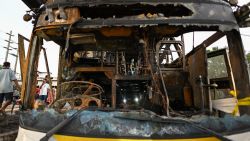 A police officer (C) inspects a burnt-out bus that was carrying students and teachers on the outskirts of Bangkok on October 1, 2024. Rescuers pulled children's bodies from the charred wreckage of a Thai school bus on October 1 after an accident turned the vehicle into an inferno, with more than 20 feared dead. (Photo by Manan VATSYAYANA / AFP) (Photo by MANAN VATSYAYANA/AFP via Getty Images)