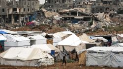 TOPSHOT - A man walks past shelter tents erected near collapsed buildings in the Bureij camp for Palestinian refugees in the central Gaza Strip on October 1, 2024 amid the ongoing war in the Palestinian territory between Israel and Hamas. (Photo by Eyad BABA / AFP) (Photo by EYAD BABA/AFP via Getty Images)