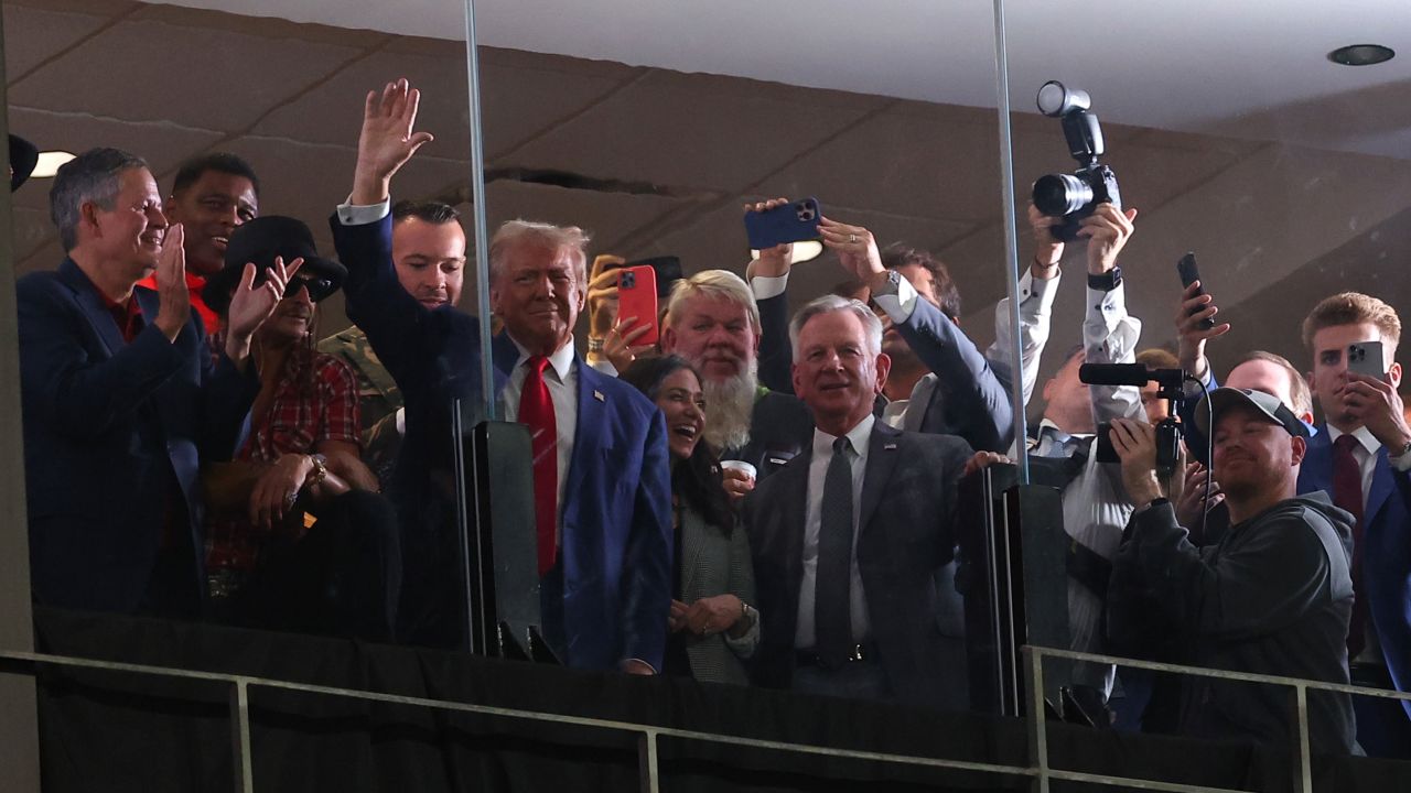 Former President Donald Trump waves from a box at Bryant-Denny Stadium during the second quarter of the football game between Alabama and Georgia in Tuscaloosa, Alabama, on Saturday evening.