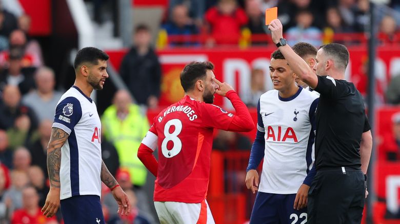 Bruno Fernandes of Manchester United is shown a red card by referee Chris Kavanagh during the Premier League match between Manchester United FC and Tottenham Hotspur FC at Old Trafford on September 29, 2024 in Manchester, England.
