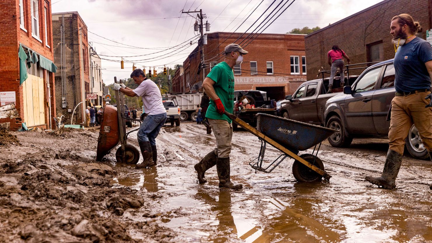 Residents and volunteers clean up on October 1, 2024, after flooding in Marshall, North Carolina.