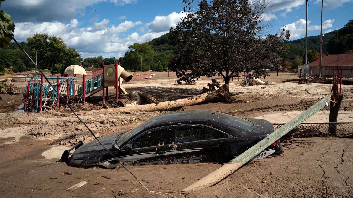 A local police car is seen half engulfed in mud, in a flooded area of Lake Lure, North Carolina.