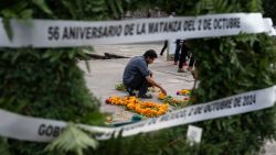 A man arranges flowers in the floor during a rally commemorating the 56th anniversary of the 1968 Tlatelolco student massacre at Zocalo square in Mexico City on October 2, 2024. In her first press conference as Mexico's president, Claudia Sheinbaum on October 2, offered a 'public apology' for a 1968 massacre of students by the army, and announced that she will present a security plan next week. (Photo by Yuri CORTEZ / AFP) (Photo by YURI CORTEZ/AFP via Getty Images)