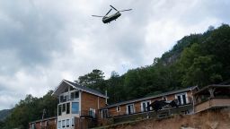 A helicopter flies above a damaged structure in downtown Chimney Rock, North Carolina, October 2, 2024, after the passage of Hurricane Helene. The death toll from powerful storm Helene, which battered the southeastern United States, has climbed to more than 155, authorities said on October 1, as President Joe Biden and Vice President Kamala Harris surveyed the damage. (Photo by Allison Joyce / AFP) (Photo by ALLISON JOYCE/AFP via Getty Images)