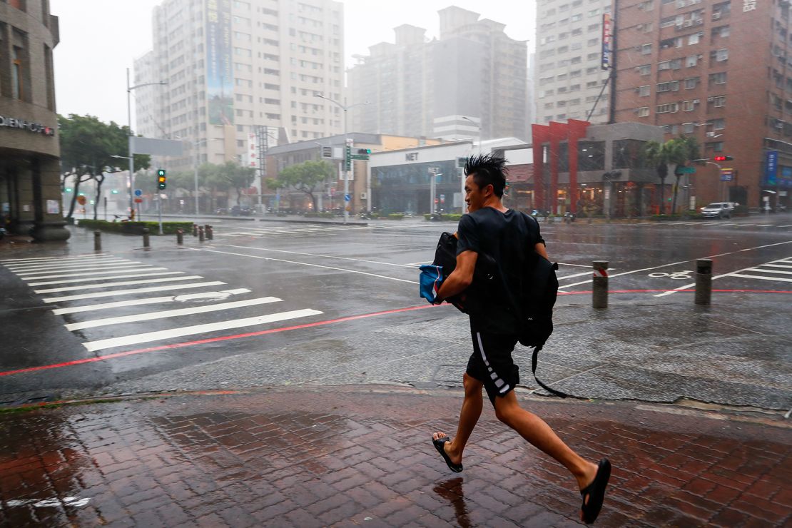 A man runs amid heavy rain and powerful winds, as Typhoon Krathon makes landfall in the port city of Kaohsiung, Southern Taiwan, on October 3, 2024.