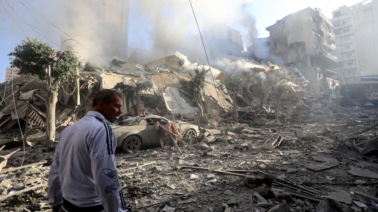 A man walks amid the rubble of a building destroyed in an overnight Israeli airstrike in Beirut's southern suburbs on October 3.