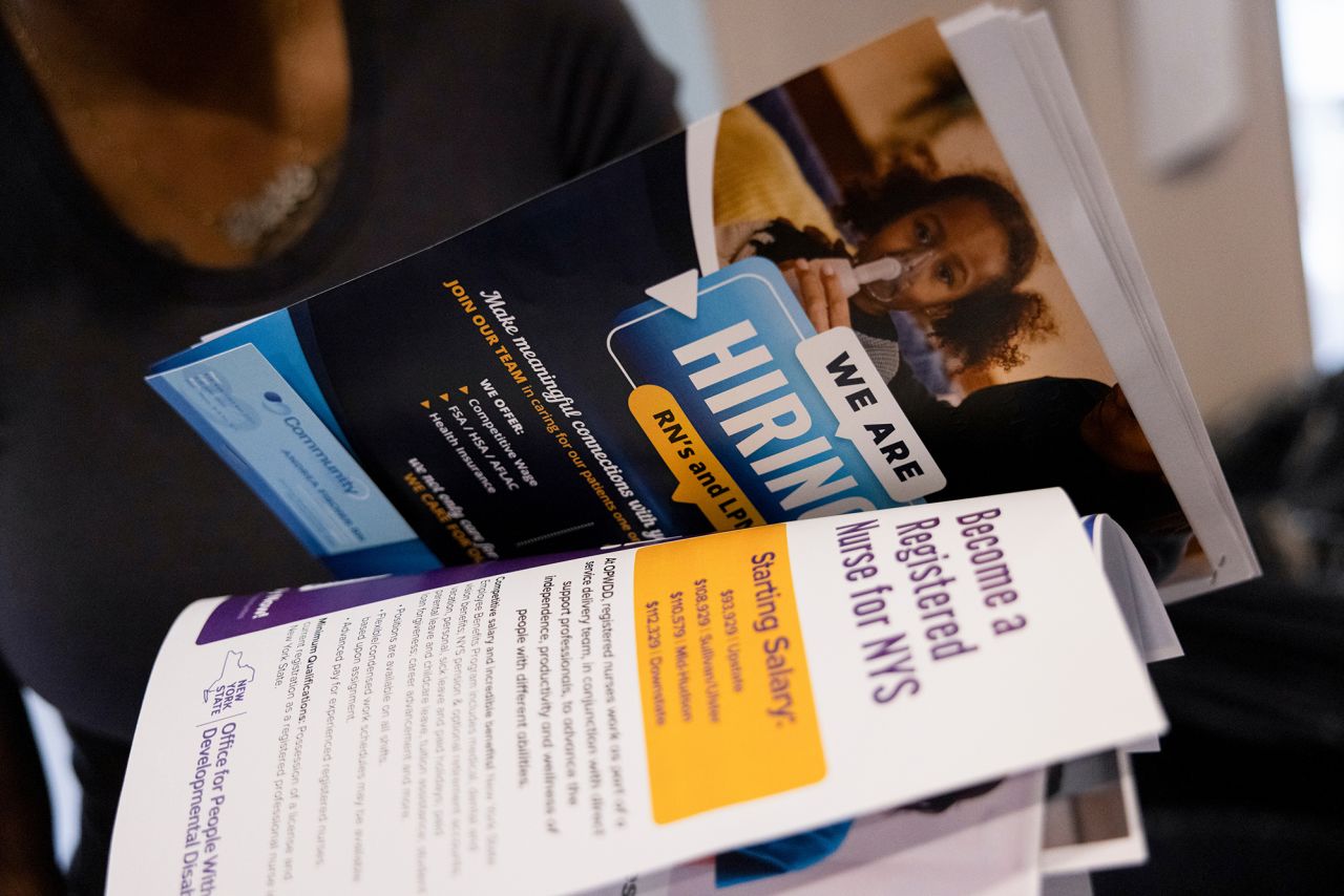 An attendee holds pamphlets at the Albany Job Fair in Latham, New York, on October 2.